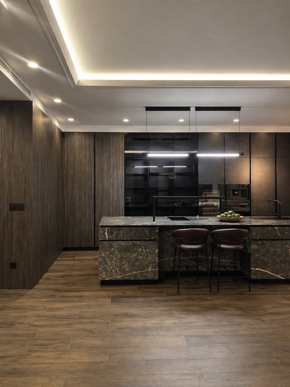 Cocina contemporánea reformada en Barcelona con carpintería oscura, isla de piedra y encuentros de techo precisos
