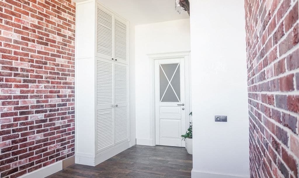 Bright hallway with brick cladding and clean white doors