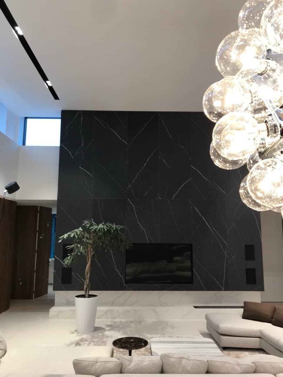 Living room fireplace with large-format dark porcelain cladding