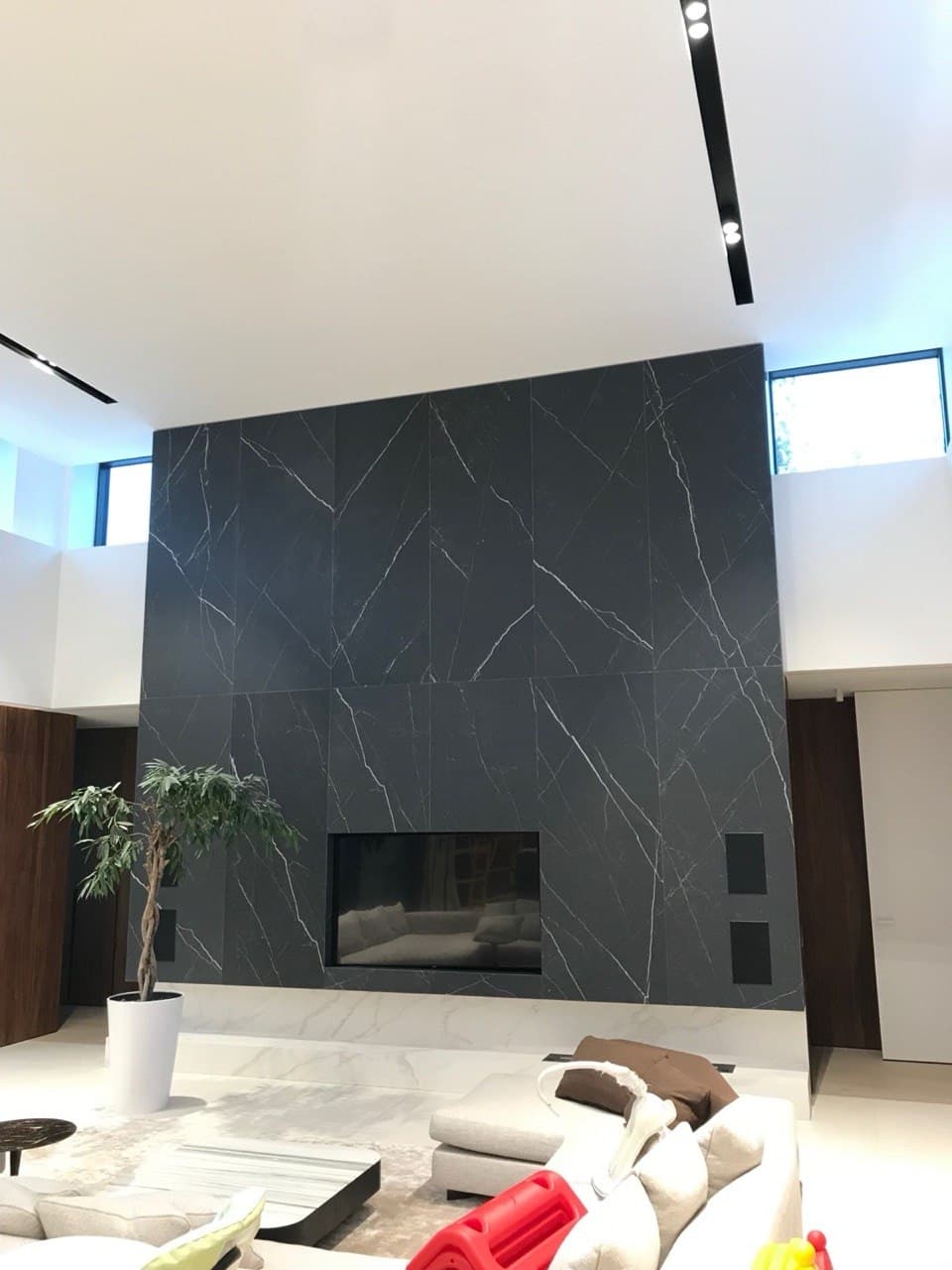 Living room with a porcelain tile floor and a dark feature fireplace