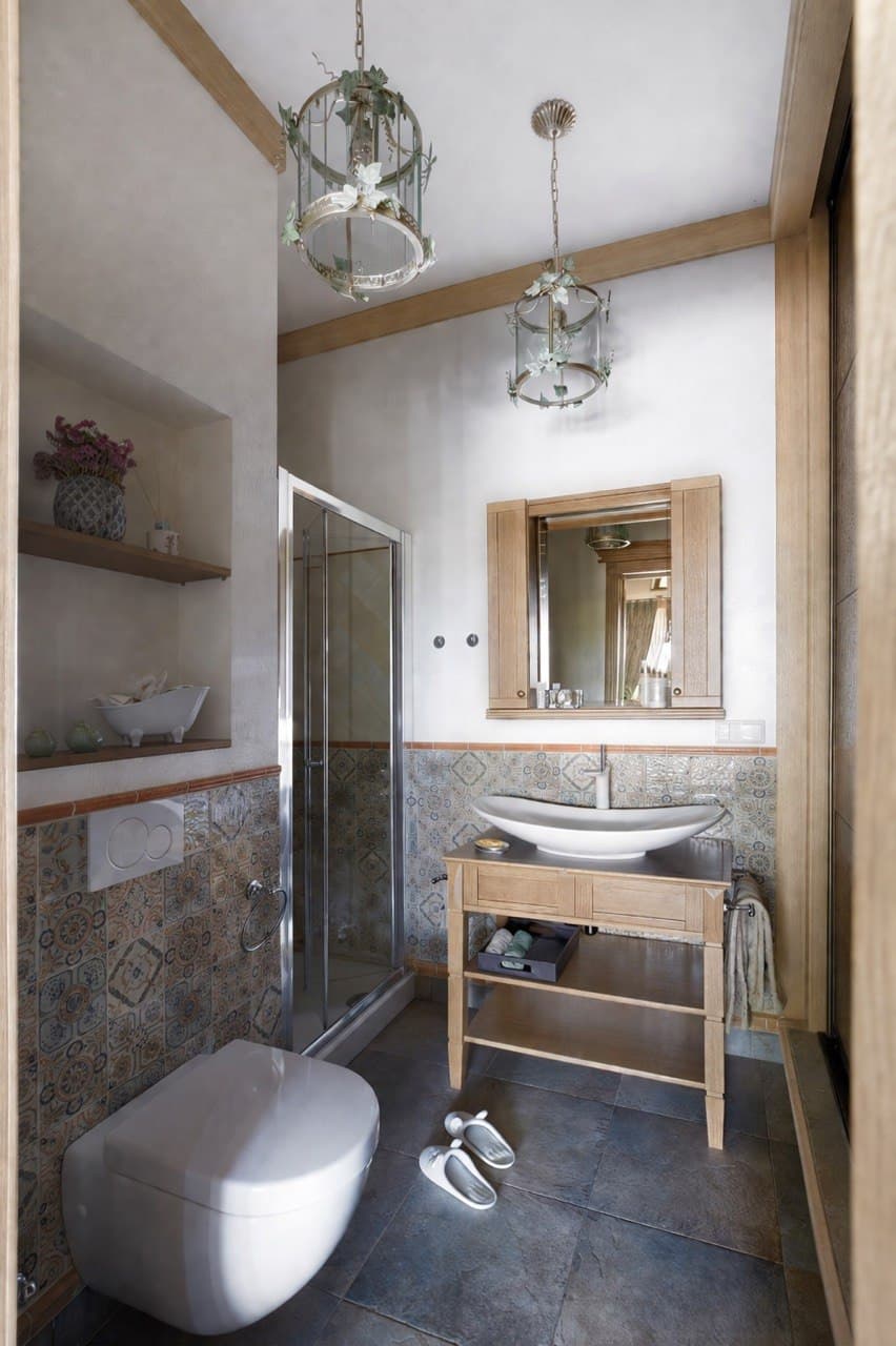 Bathroom with decorative plaster, patterned tile wainscoting, and a wood vanity