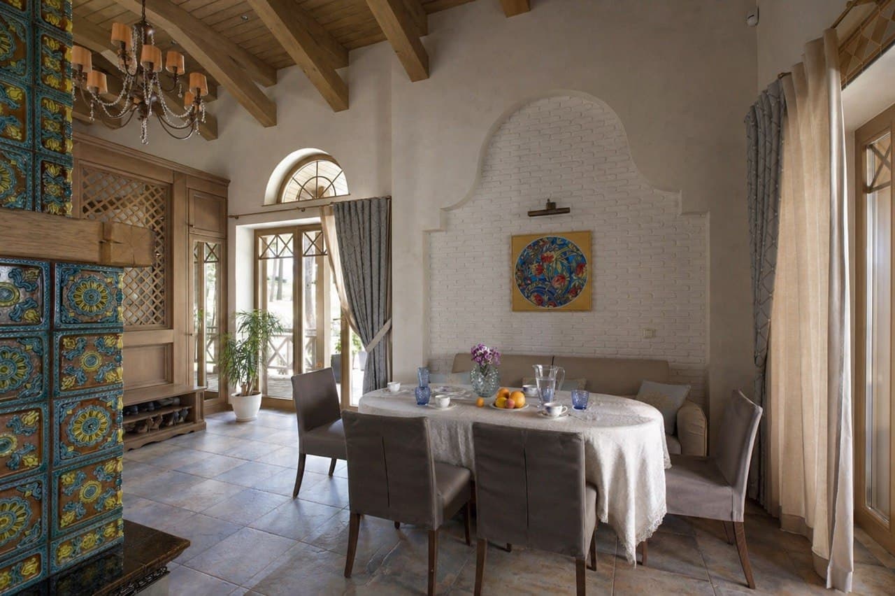 Dining room with lime plaster walls, a wood beam ceiling, and a tiled stove