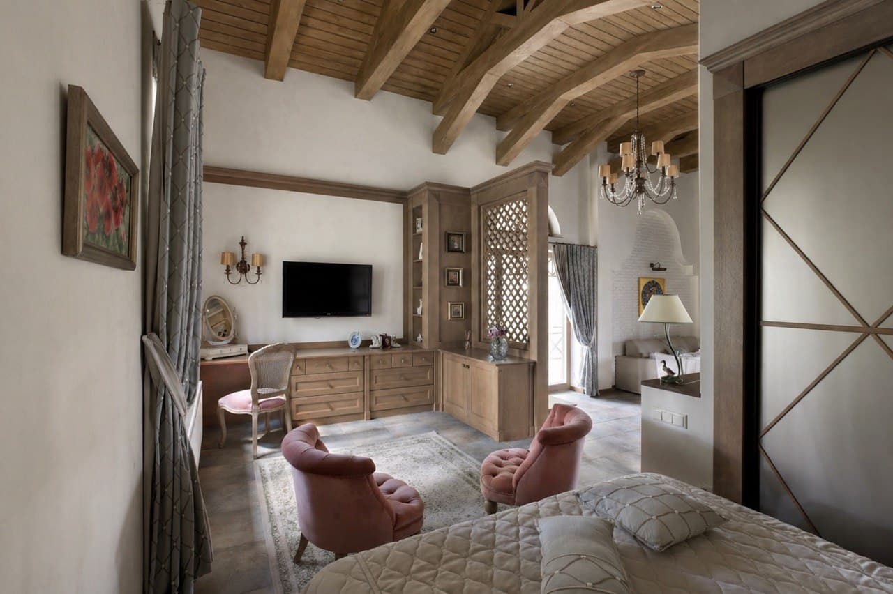 Sitting area with wood cabinetry, lime plaster walls, and a vaulted beam ceiling