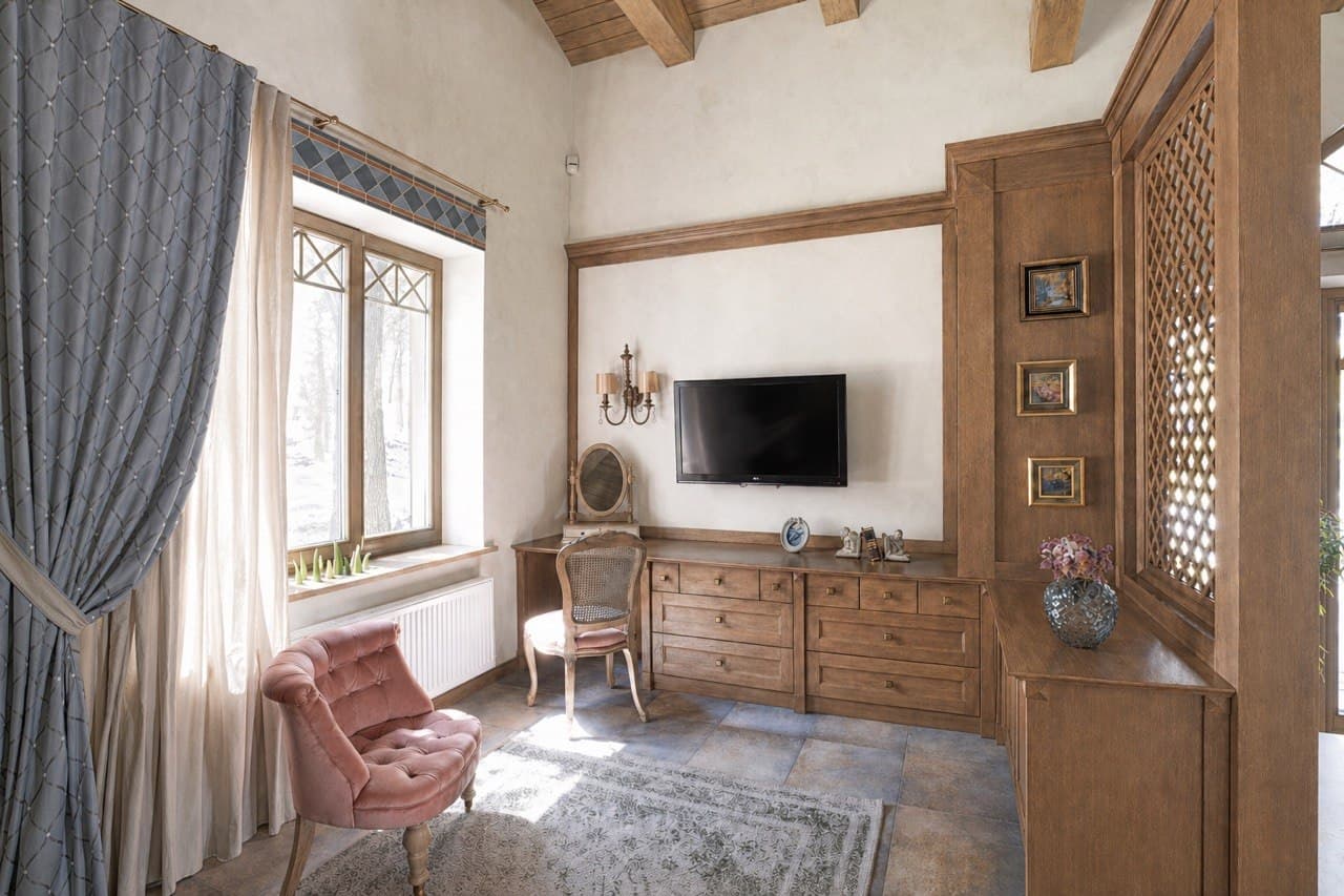 TV lounge with mineral wall finish, wood cabinetry, and draped window light
