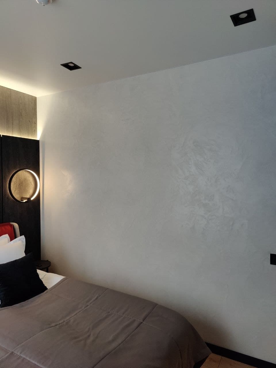 Bedroom wall close-up with a smooth lime coating and a shadow gap