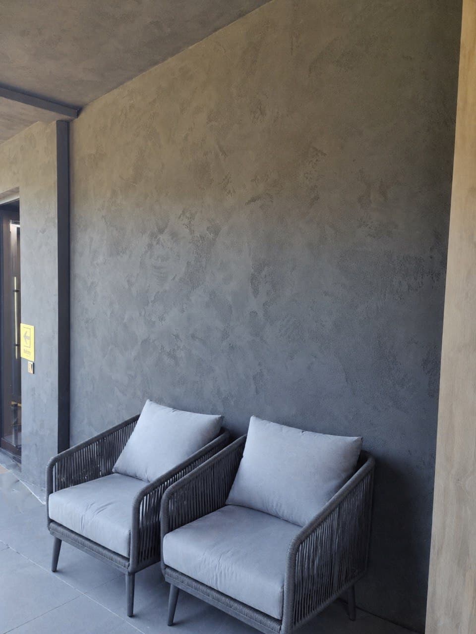 Decorative plaster feature wall with a lounge chair and warm mineral texture