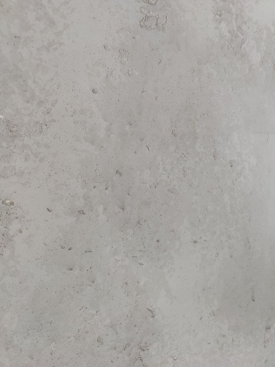 Lime-based surface close-up with tonal movement and subtle pitting