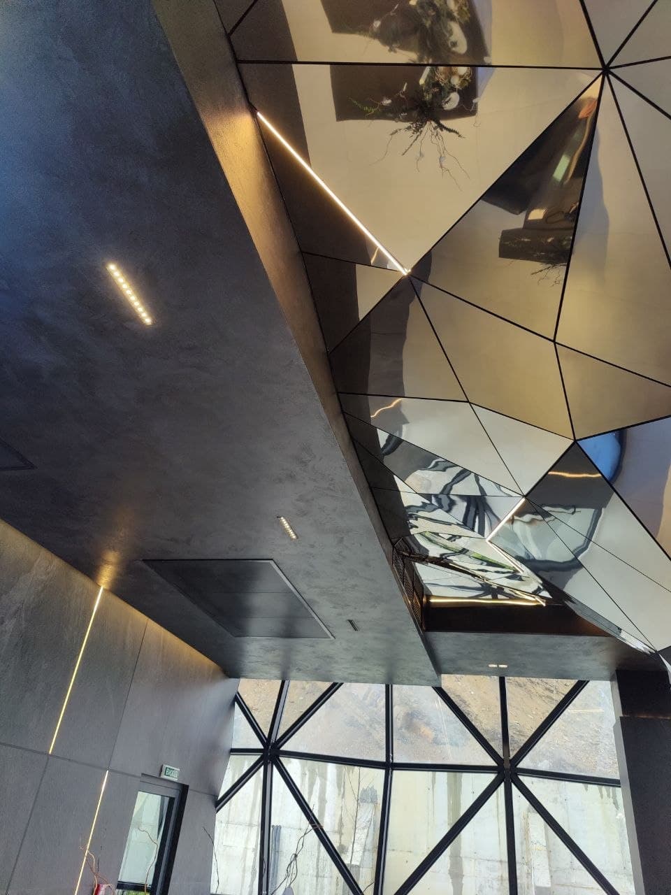 Mirrored ceiling detail with geometric reflections and light lines