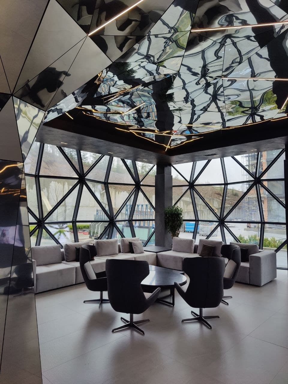 Mirrored lounge with panoramic glazing and sculptural seating