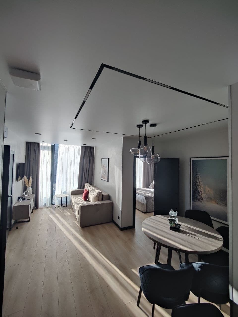 Open-plan room with an architectural lighting track and layered surfaces