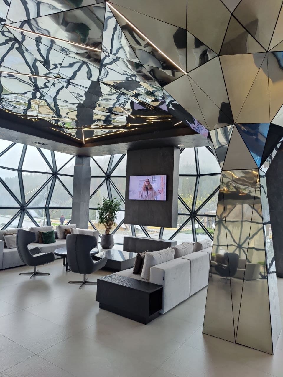 Reflective lounge interior with a geometric ceiling and premium decor