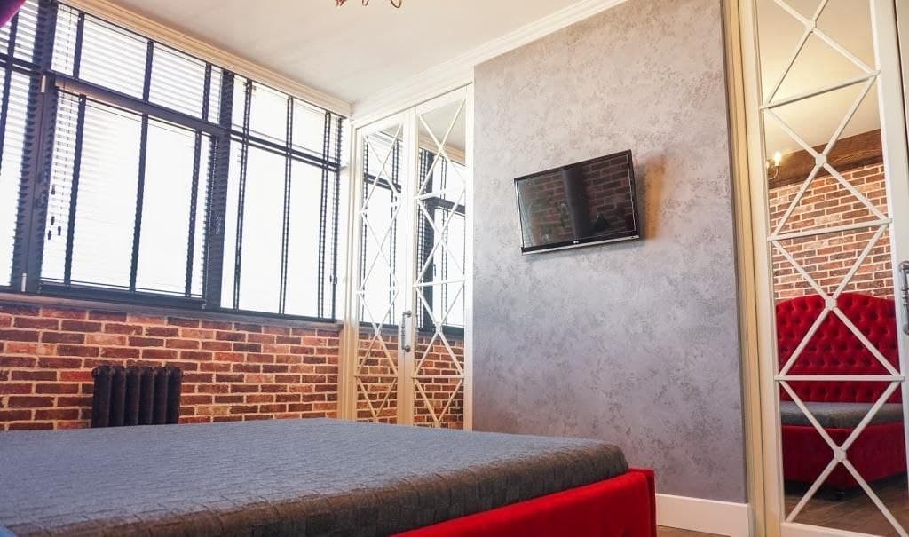 Bedroom with brick walls, mirrored wardrobe, and a textured decorative finish