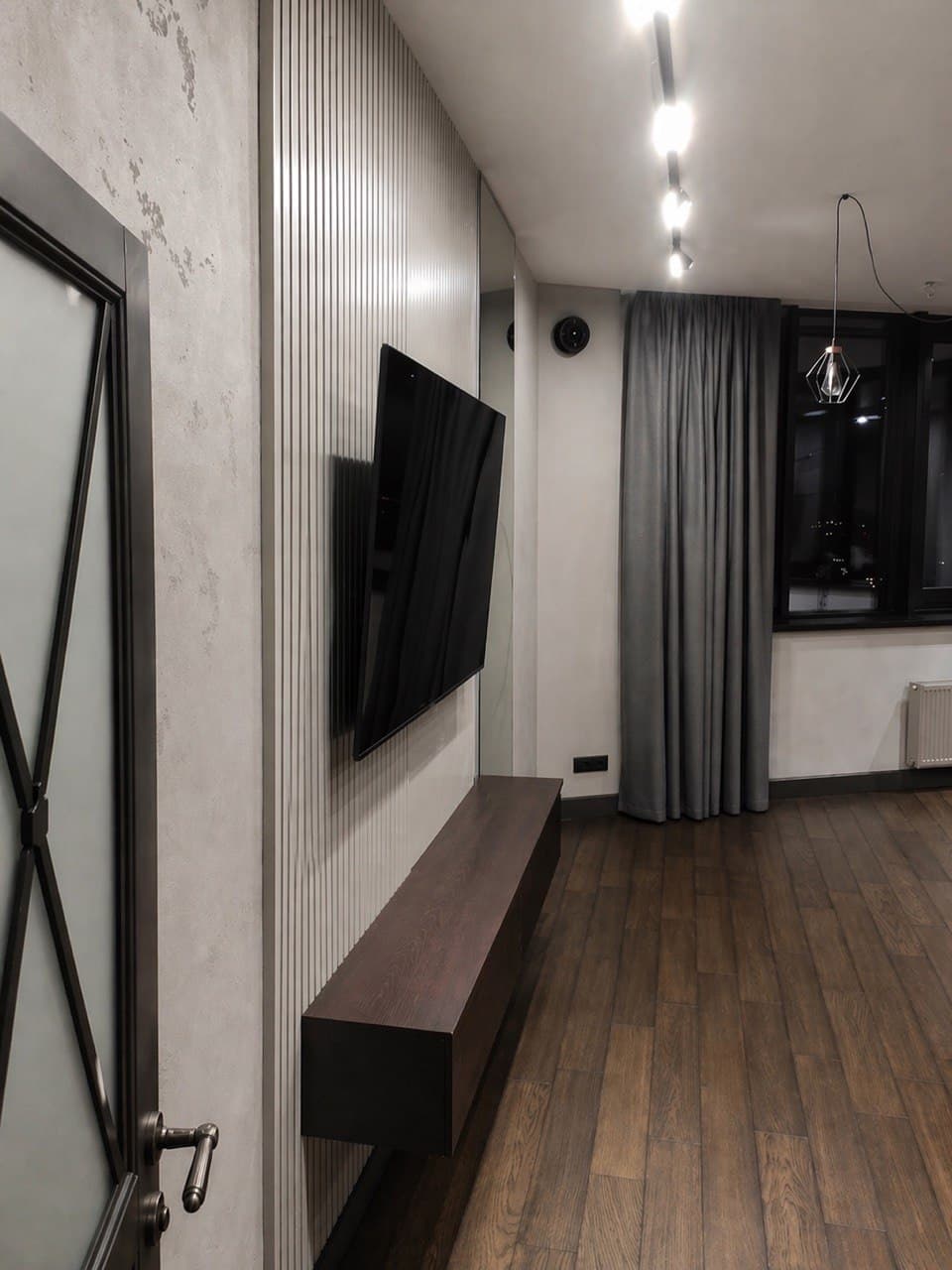 Corridor with concrete-effect walls, linear lighting, and minimalist joinery