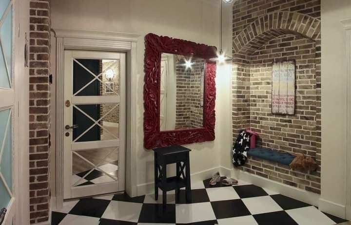 Entry hall with brick walls, a checkered floor, and a statement mirror