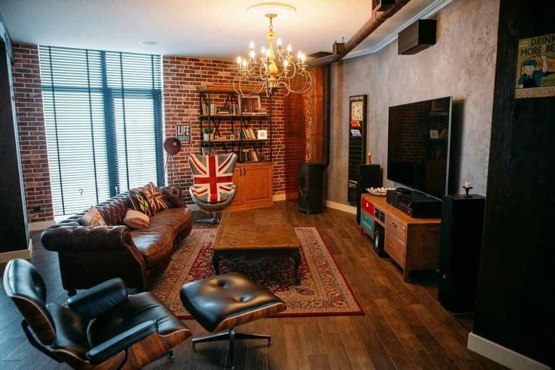 Loft lounge with brick walls, textured paint, and a dark wood floor
