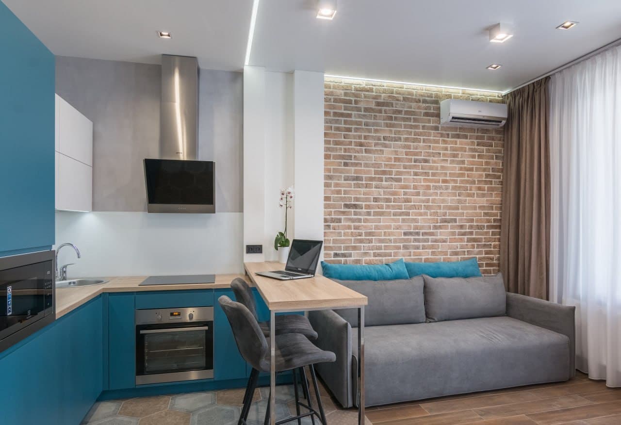 Compact kitchen with a brick wall, decorative ceiling line, and a breakfast desk