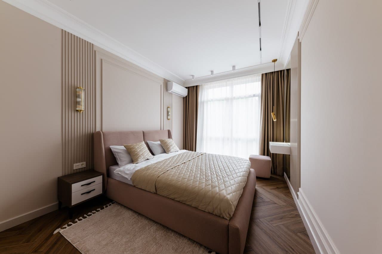 Bedroom with a fluted wall detail, paneled surfaces, and a compact nightstand
