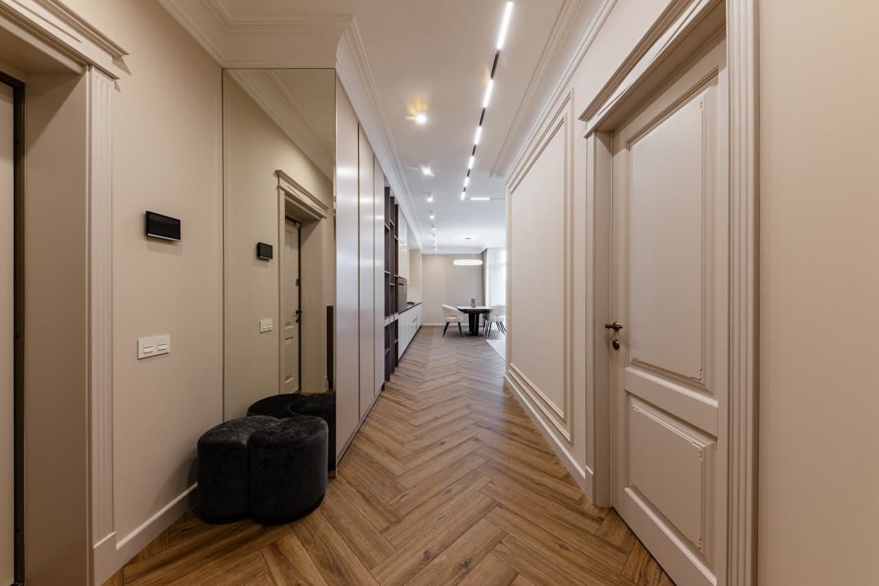 Hallway with concealed lighting, architectural panels, and aligned doors