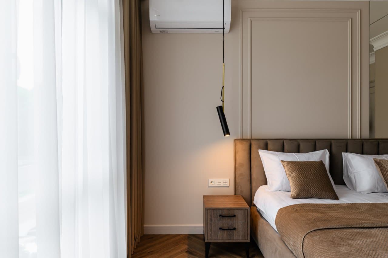 Headboard detail with decorative wall panels and soft brass accent lighting