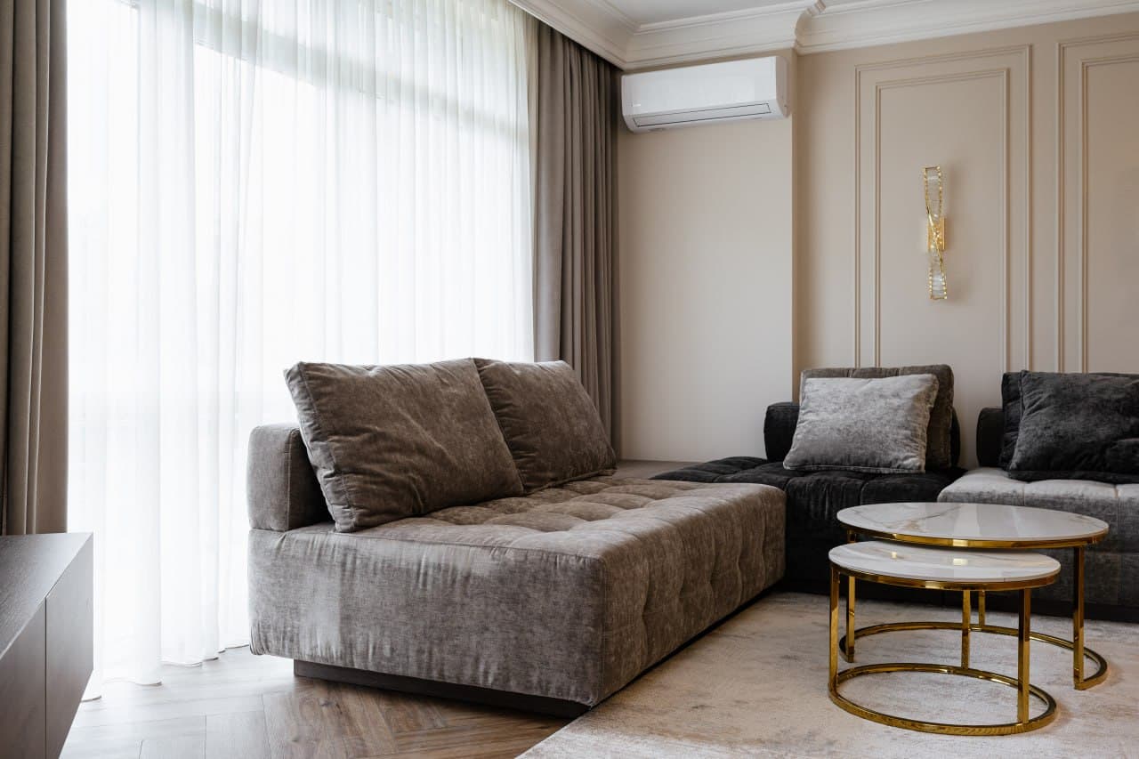 Living room with full-height curtains, paneled walls, and a soft neutral palette