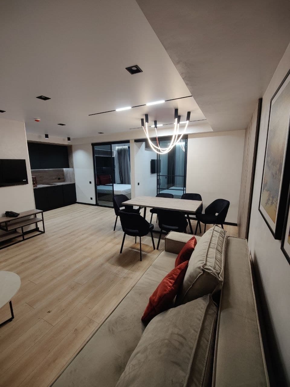 Lounge perspective with a linear kitchen, clean geometry, and soft lighting