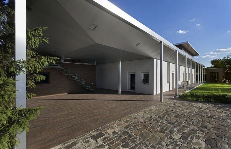 Exterior patio with architectural tiling, a covered walkway, and a modern villa volume