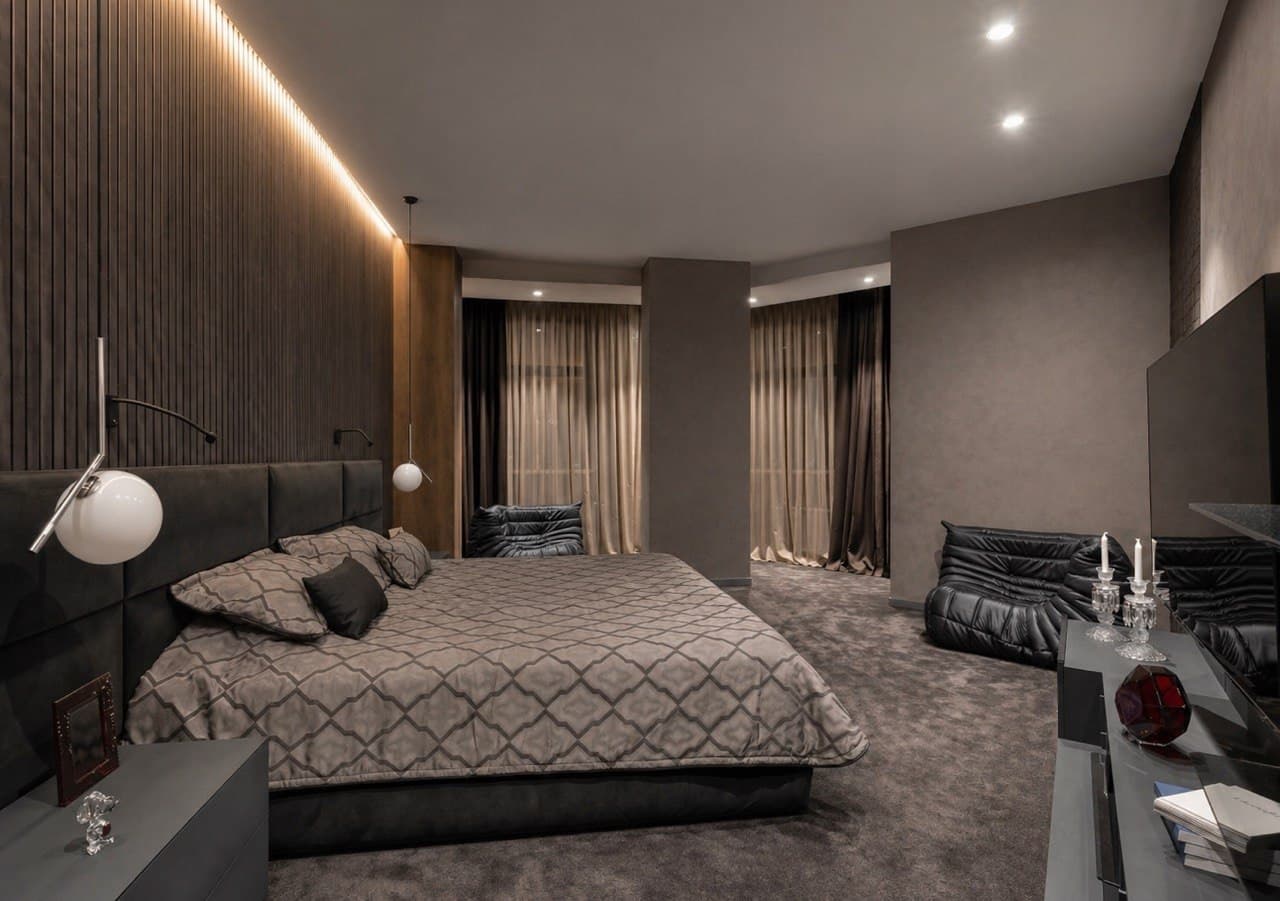 Contemporary bedroom with decorative wall panels, curtain lighting, and a lounge corner