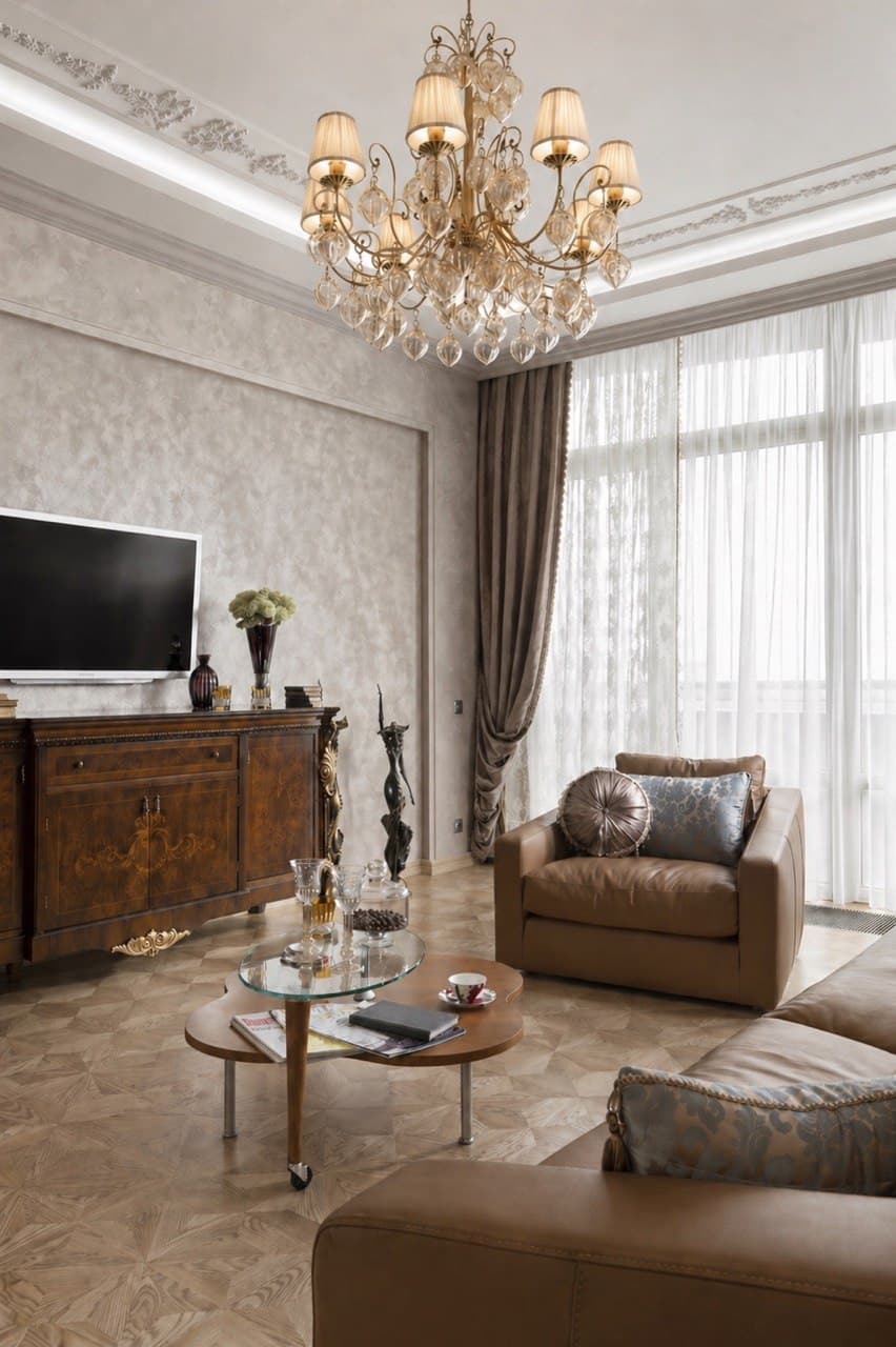 Living room corner with classic decorative plaster, chandelier, and window drapery