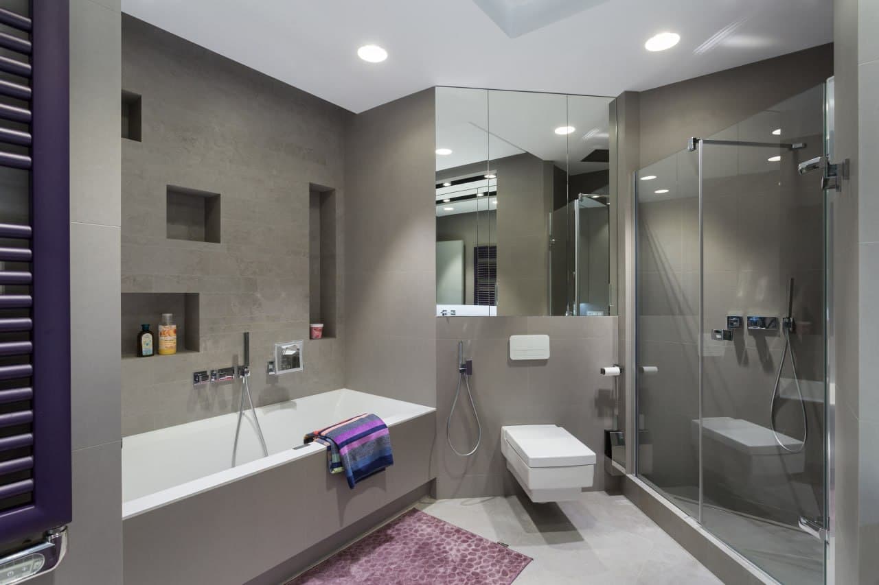 Bathroom with seamless surfaces, a glass shower, and a muted grey finish