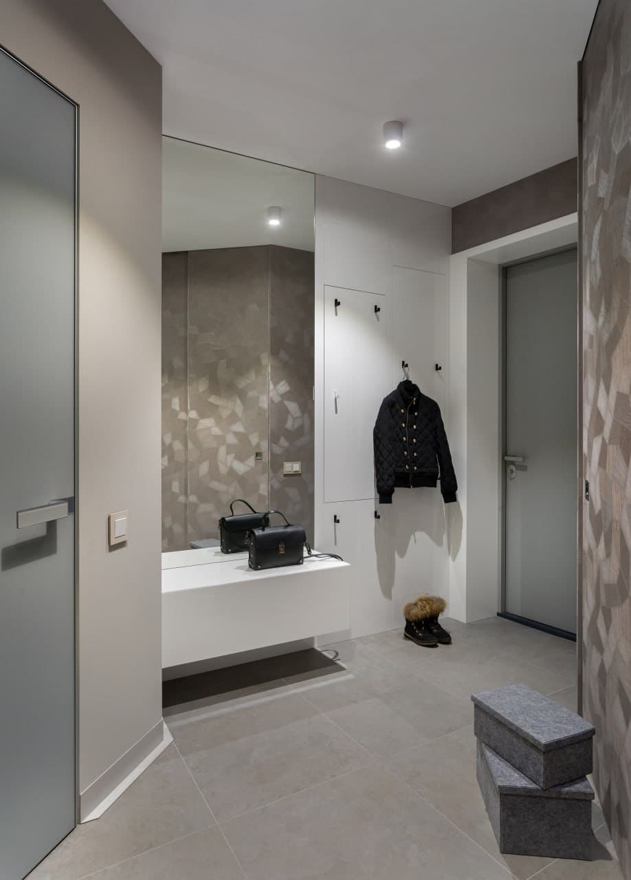 Entry corridor with a textured wall finish and concealed lighting