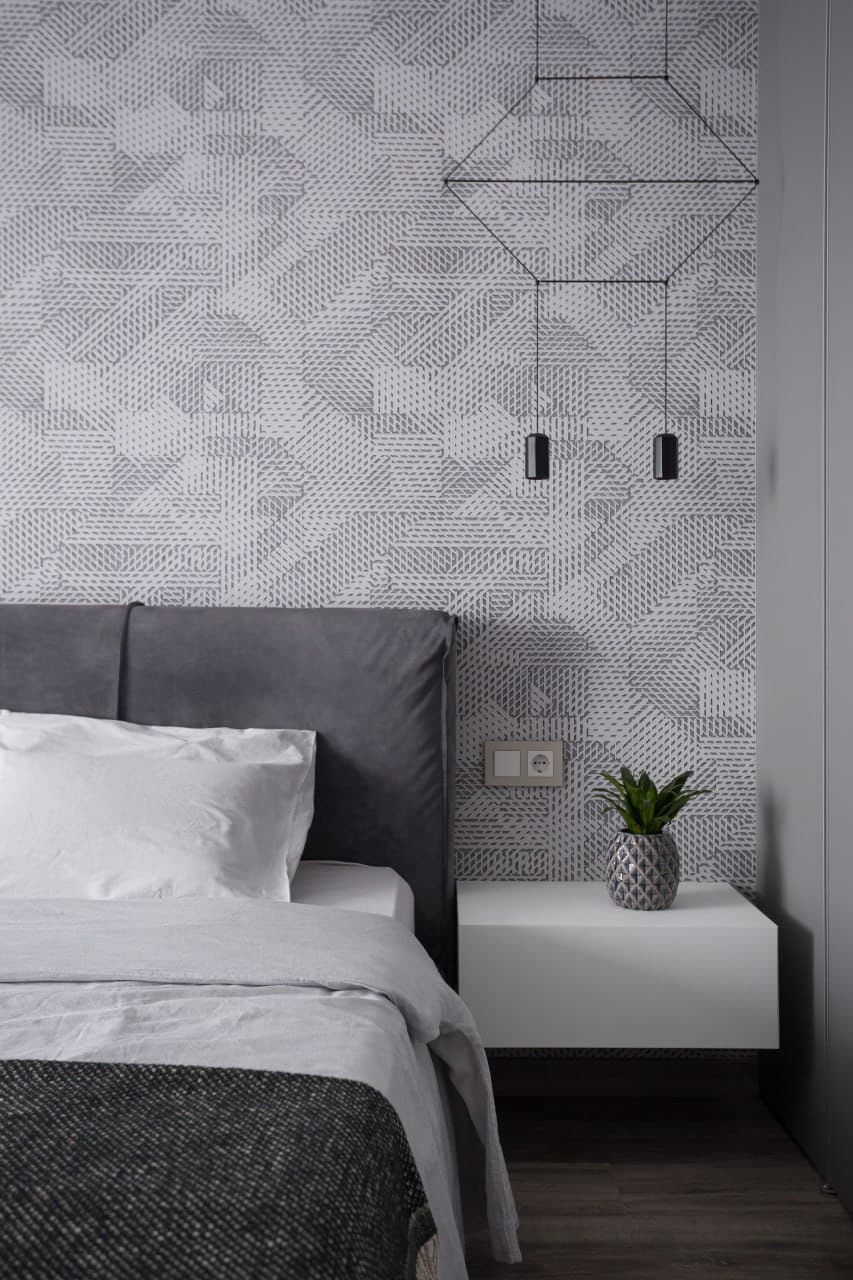 Upholstered headboard wall with an artistic textured finish and pendant lights