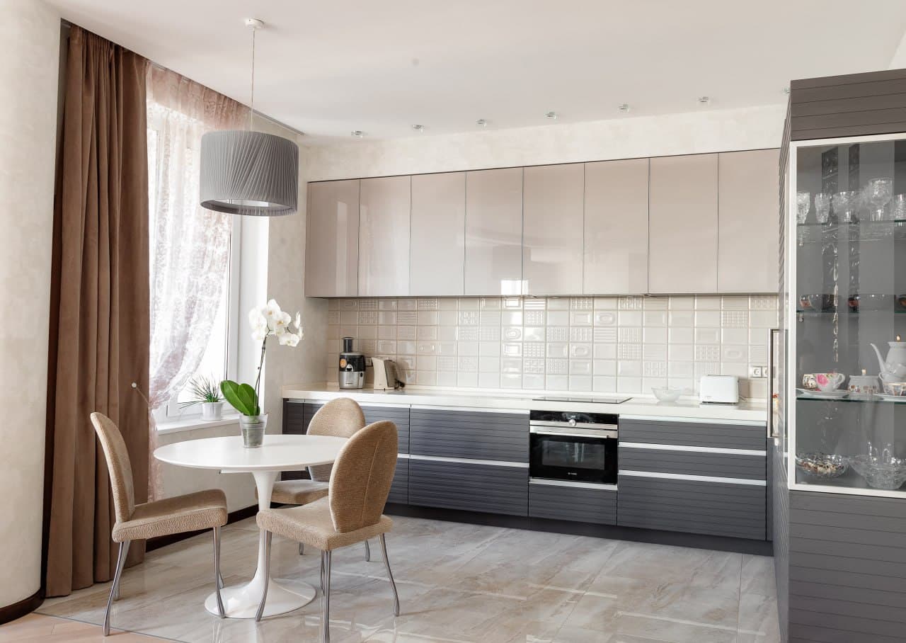Kitchen with satin cabinetry, clean lines, and a decorative wall finish