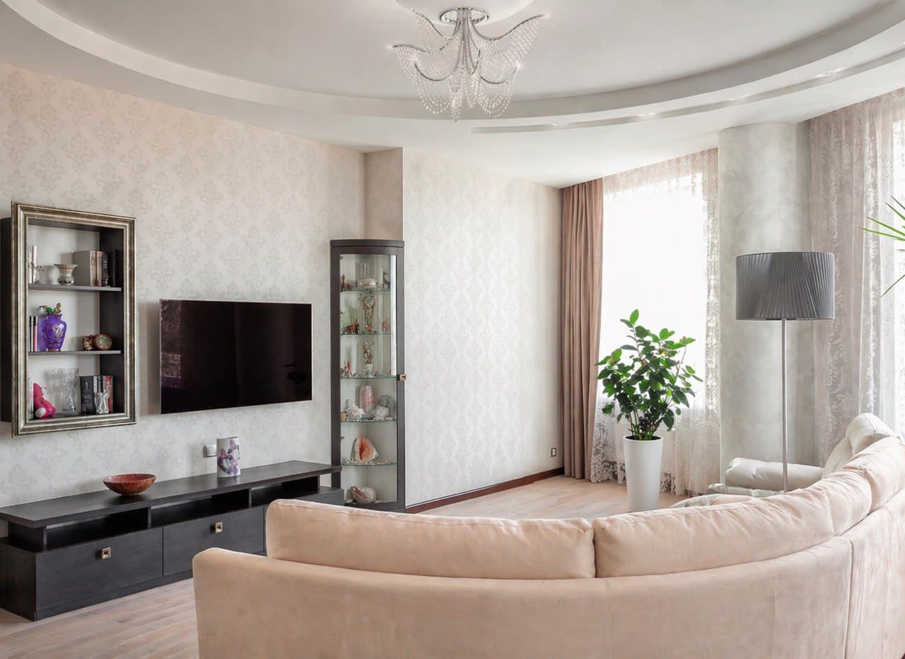 Living room with soft decorative plaster, a curved ceiling detail, and a cream sectional