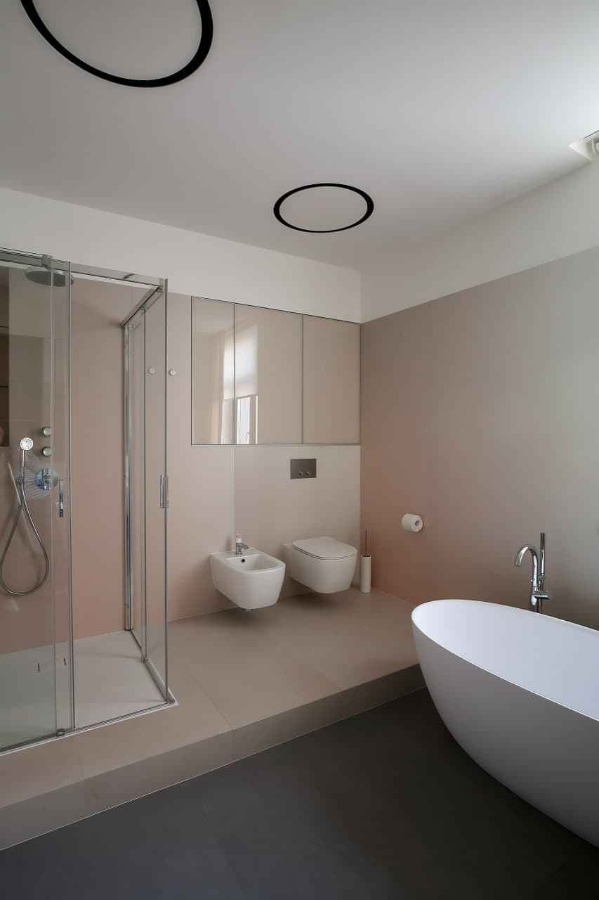 Bathroom with a freestanding tub, glass shower, and seamless decorative surfaces