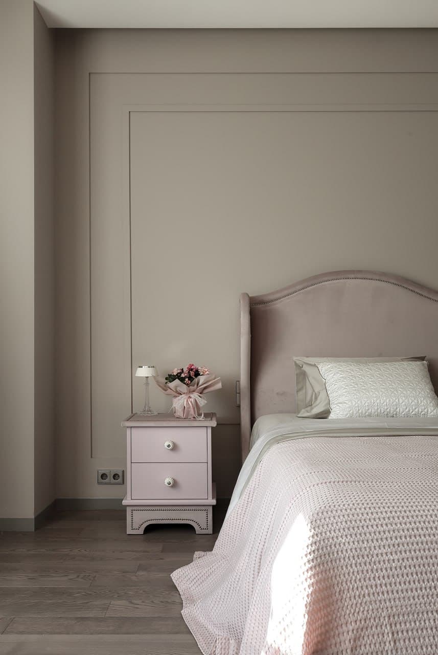 Bedroom with integrated wall panels, minimalist detailing, and blush textiles