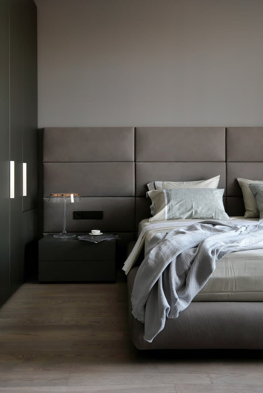 Bedroom with upholstered wall panels and a soft matte decorative finish