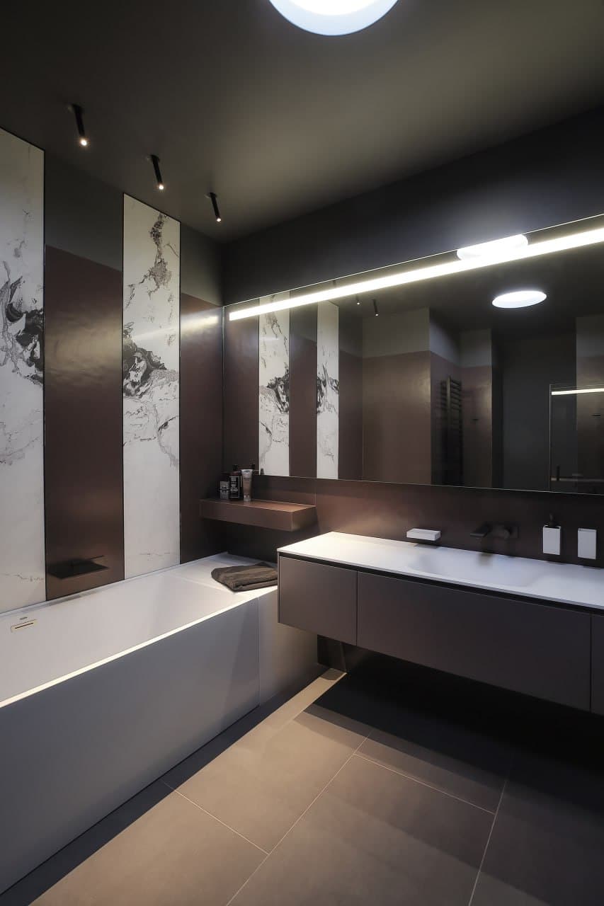 Dark bathroom with microcement surfaces, linear lighting, and a double vanity