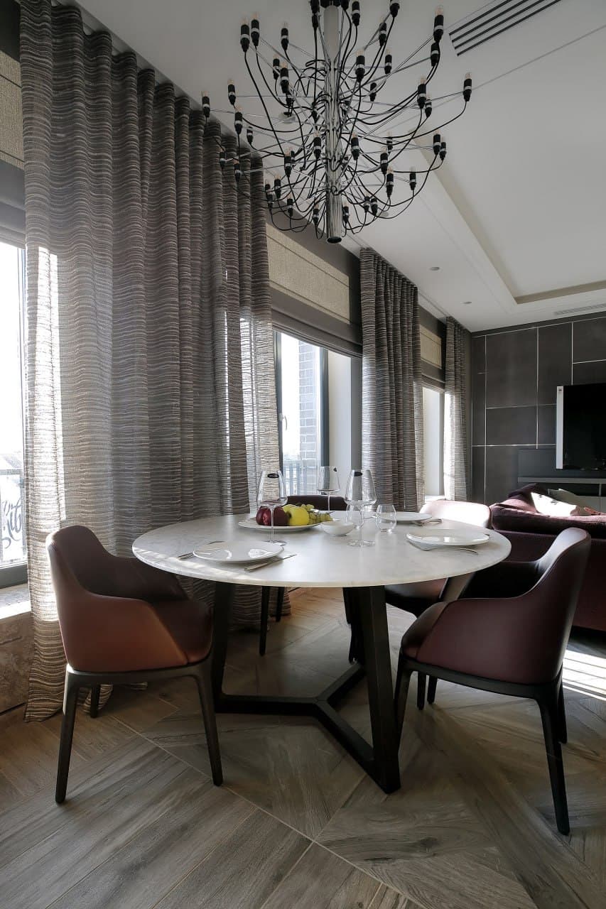 Dining room with floor-to-ceiling drapery, a decorative ceiling, and a round table