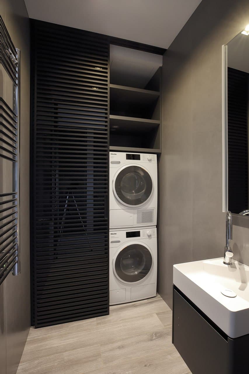 Laundry-bathroom zone with dark slatted panels and seamless surfaces