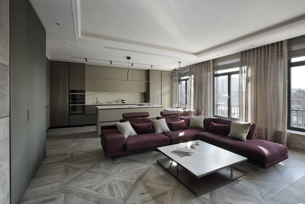 Lounge with a modular sofa, a microcement floor, and an open kitchen
