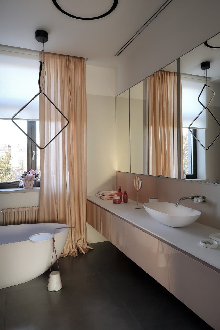 Luxury bathroom with decorative plaster walls, bathtub, and layered lighting