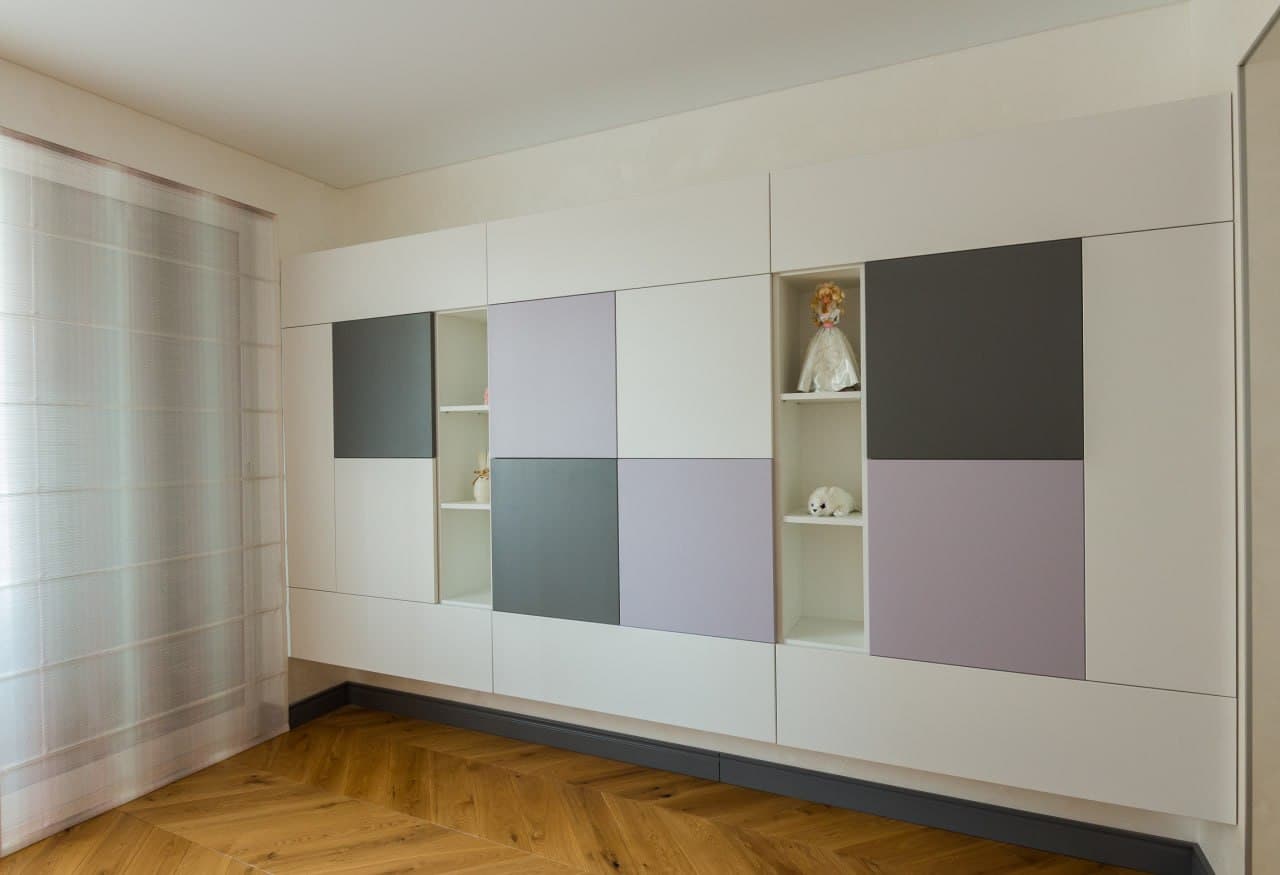 Custom wardrobe wall with pastel panels and clean white joinery