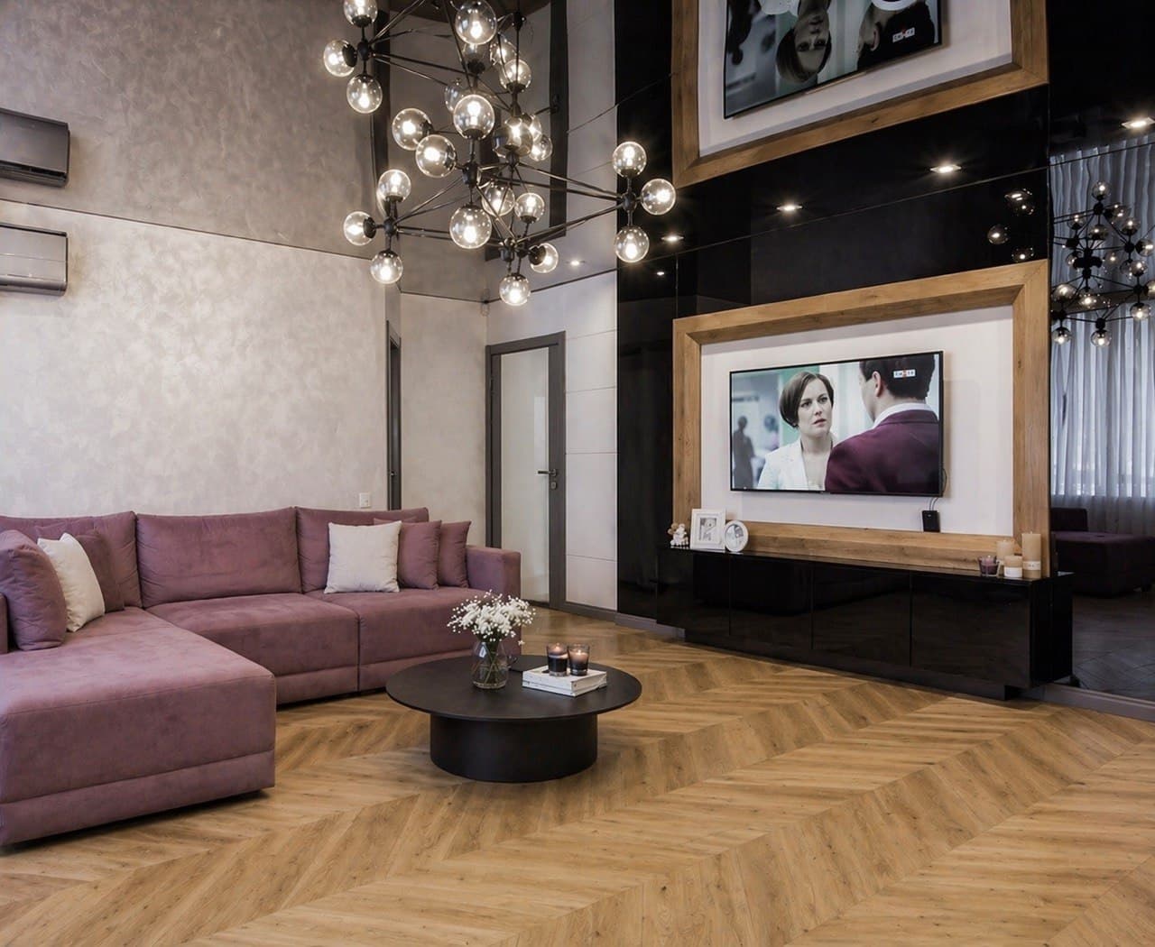 Living room with a textured decorative wall, black media panel, and a blush sectional