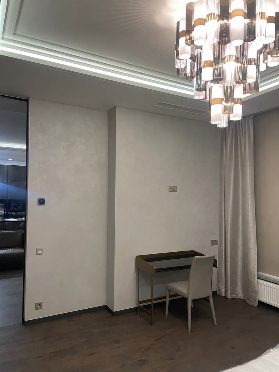 Bedroom dressing corner with cove lighting, curtains, and a writing desk