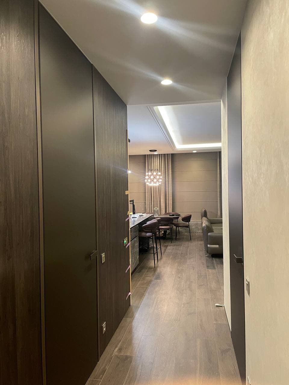 Corridor with dark wall panels, timber floor, and an aligned sightline