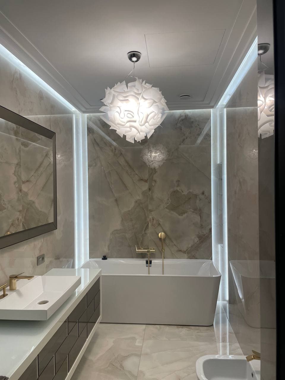 Master bathroom with seamless stone surfaces and a suspended tub