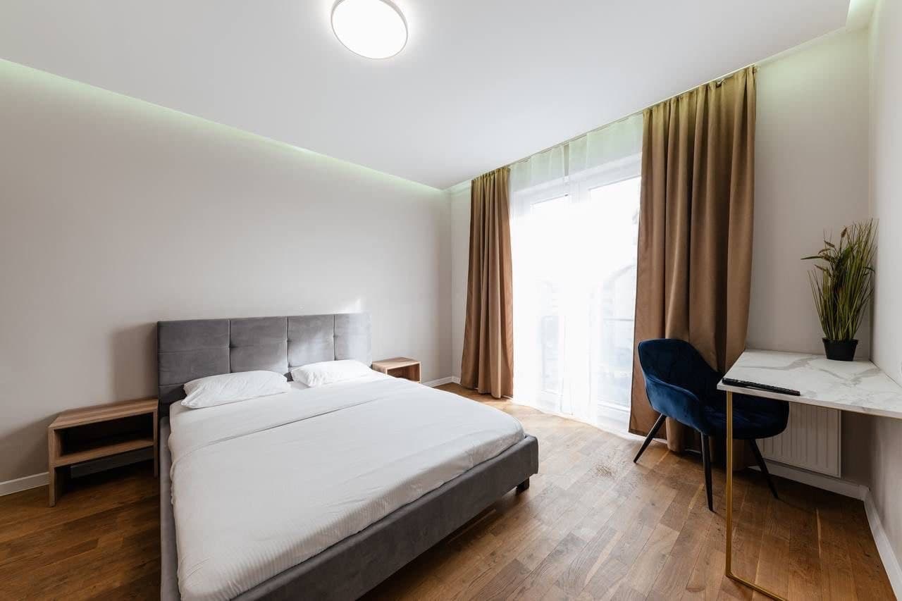 Bedroom with smooth decorative paint, perimeter lighting, and a compact workspace