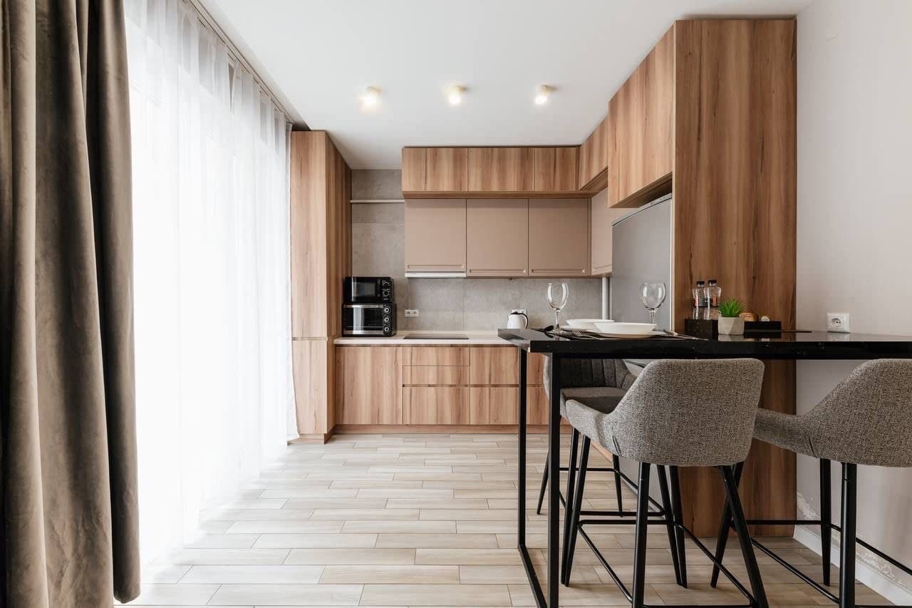 Compact kitchen with a breakfast bar, soft wood cabinetry, and natural light